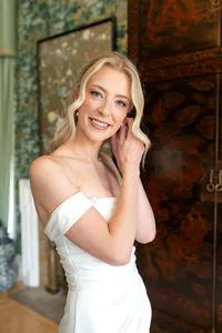 Bride wearing soft glam makeup with glowing skin and half up glam waves
