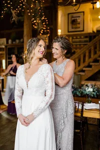 Bride wearing soft glam bridal makeup with glowing skin and lashes with a romantic half up hairstyle