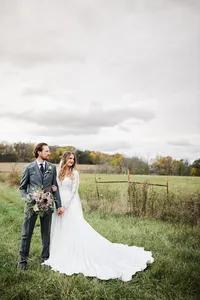 Bride wearing soft glam bridal makeup with glowing skin and lashes with a romantic half up hairstyle