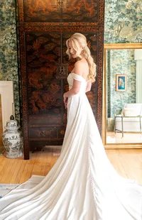 Bride wearing soft glam makeup with glowing skin and lashes and a half up glam waves hair style