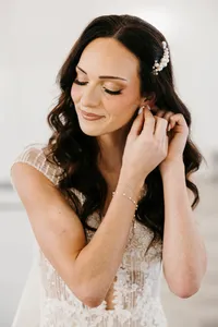 Bride wearing soft glam bridal makeup with glowing skin and lashes with glam waves with hair extensions