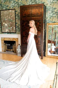 Bride wearing soft glam bridal makeup with glowing skin and lashes with half up glam waves