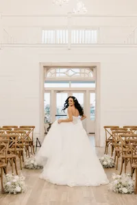 Bride wearing soft glam bridal makeup with glowing skin and lashes with glam waves with hair extensions
