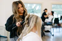 Bride getting a romantic updo with loose face framing pieces by The Bridal Glam Group