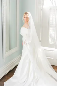 A bride with soft glam makeup with a red lip and a romantic updo with loose face framing pieces