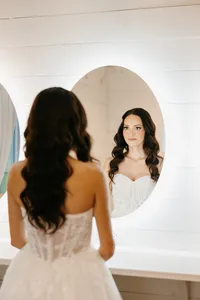 Bride wearing soft glam bridal makeup with glowing skin and lashes with glam waves with hair extensions