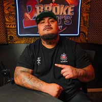 Uso Jax seated in a podcast studio wearing a Samoa rugby shirt