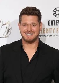 Michael Bublé smiling in a black suit at an event