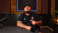 Uso Jax seated in a podcast studio wearing a Samoa rugby shirt
