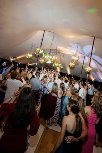 Wedding guests celebrating together beneath an elegant tent.