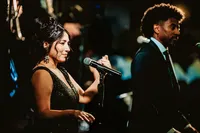 Legacy Band vocalist performing at an evening event