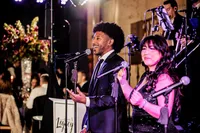 Legacy Band vocalists performing together under colorful stage lighting