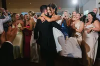 Newlyweds sharing their first dance surrounded by wedding guests