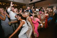 Wedding guests celebrating and dancing at a lively reception