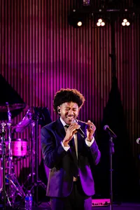 Legacy Band vocalist performing at a wedding reception under magenta lighting