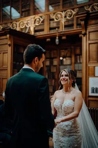 Modern wedding photography at Royal College of Physicians Edinburgh featuring the bride smiling at her groom during vows in the New Library