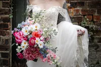 Modern wedding photography at the Bothy Glasgow showcasing her bouquet of bright flowers and lace wedding dress