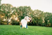 Cooper dipping Marguerite for a kiss on a wide park lawn at golden hour
