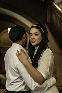 Alisson and Alexis embracing beneath a stone archway during their elopement at the Allegheny County Courthouse in Pittsburgh