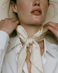 krista5123_Woman_tying_a_cream_silk_scarf_loosely_at_her_neck_8f4be788-f0b6-46d5-9b33-3e62dcd1751d_3