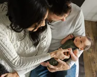 Newborn baby Kai with sibling during a lifestyle newborn photography session