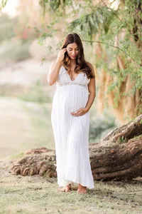 Pregnant woman in a flowing white gown during a Palm Springs maternity session