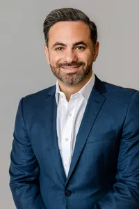 Man in a suit posed for a corporate headshot for Sherwood Partners