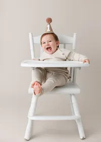 Baby seated on a stool during a La Quinta studio first birthday photography session