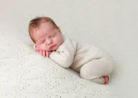 Sleeping newborn baby captured in a soft posed studio portrait