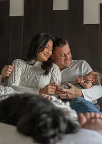 Newborn baby Kai with family during an in home lifestyle newborn session
