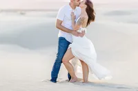 Couple sharing an embrace on the desert dunes, Palm Springs photography session
