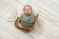 Newborn baby swaddled and posed for a studio portrait in La Quinta