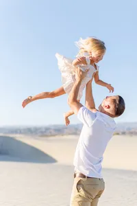 Father throws daughter in the air during their palm springs family session