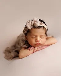 Sleeping newborn baby captured in a soft posed studio portrait