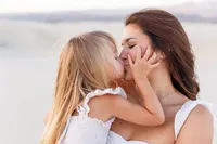 Mother lifting and kissing child during a Palm Springs portrait session