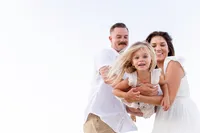 Family makes little girl fly through the air during their family portrait session