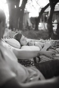 Mother laying with newborn during her in home newborn photo session in houston texas