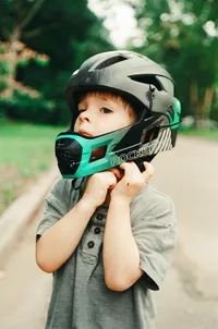 Boy buckling his helmet during an at home family photo session in houston texas