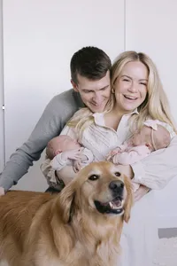 Family portrait with newborn twins and their golden retriever