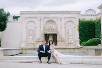 Couple seated on the steps of a columned building during their engagement session