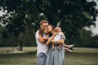 Grand Rapids family photographer Grace Wan captures a mother and father holding their toddler and baby as they all interact.