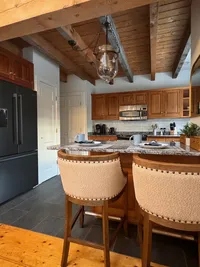 Kitchen with exposed wood beams and counter seating at Brookside Retreat