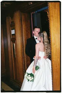 Destination film wedding photographer Grace Wan captures a groom holding his bride by the waist as he kisses her temple.
