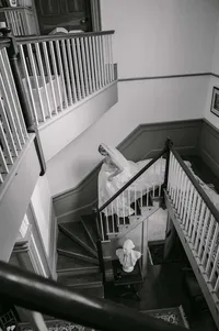 Black-and-white overhead view of a bride on a sweeping white staircase