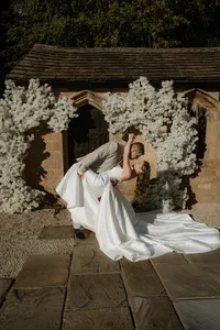 bride and groom outside Yorkshire wedding venue with white floral display around the entrance