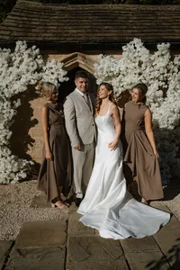 wedding party outside wedding venue with white floral display around the entrance