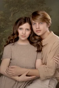 Fine art sibling portrait styled against a painterly backdrop