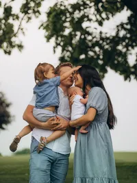 A father holds their toddler as a mother holds their baby during family photos with The Garden Photo + Film.