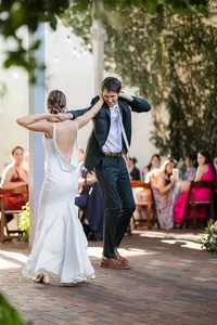 Sam and Stu laughing during their first dance at an outdoor wedding reception, photographed by Dove and Fox