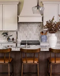 Kitchen design in Asheville, NC, with creamy white cabinets, tile backsplash, and warm wood island.